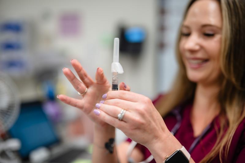 a woman medical provider flicking a needle